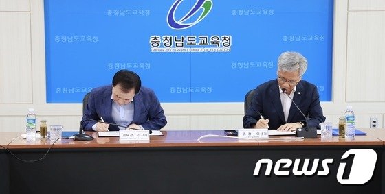 김지철 교육감(왼쪽)과 이성기 총장이 업무협약서를 작성하고 있다. 출처=뉴스1